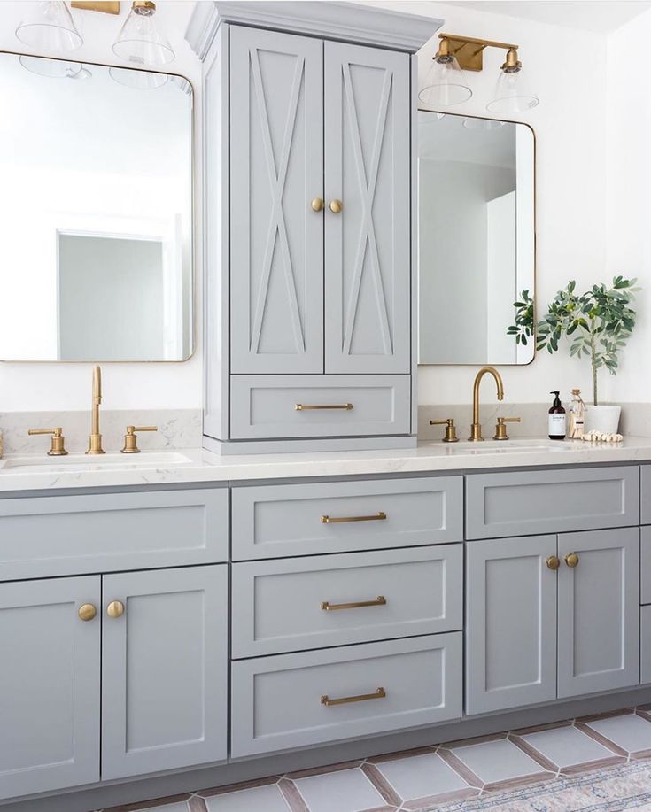 a bathroom with two sinks, mirrors and cabinets in grey colors on the countertop