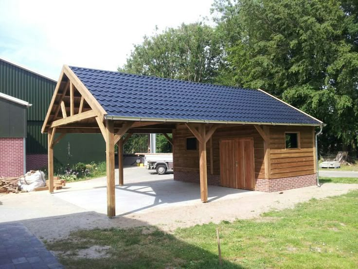 a wooden garage with a blue roof and two doors on the side of the building