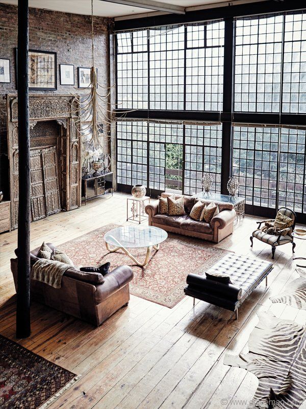 a living room filled with furniture and large windows