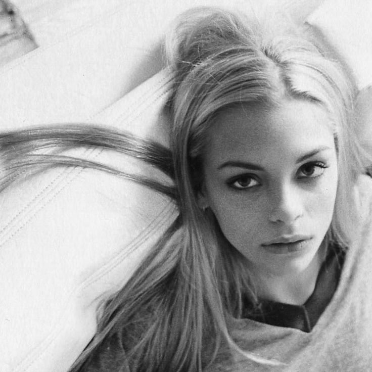 a woman laying on top of a bed with long hair