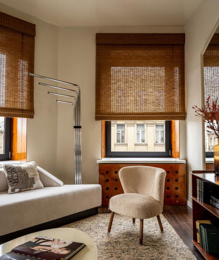 a living room filled with furniture and windows covered in shades of bamboo blind coverings