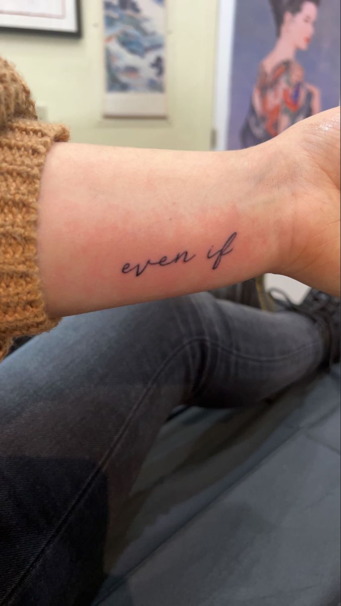 a woman's arm with the word even if tattooed on it