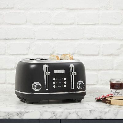 a toaster sitting on top of a counter next to a jar of jam and some books