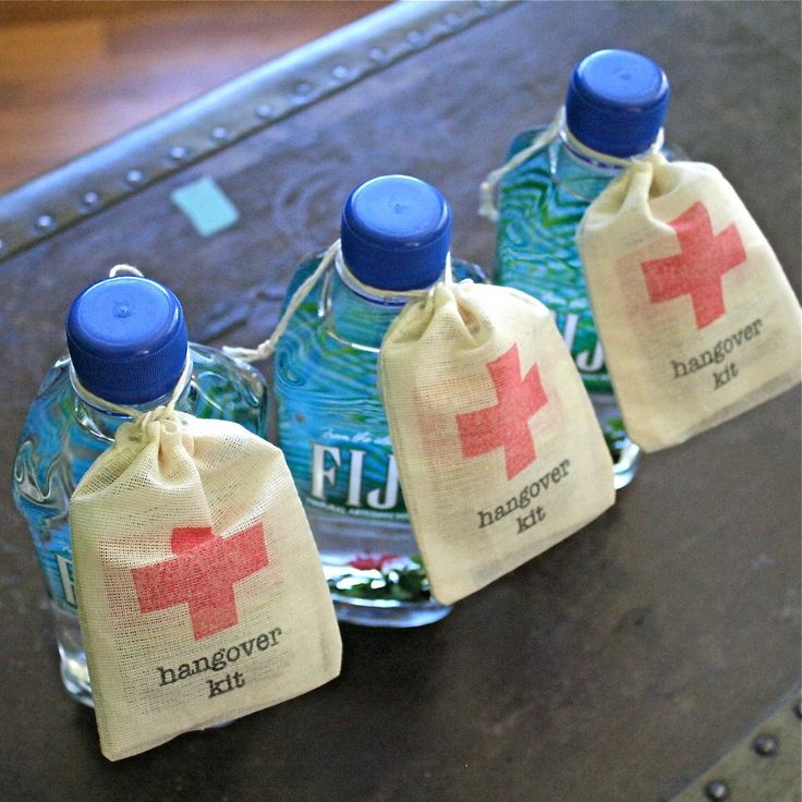 three bottled water bottles sitting on top of a table next to a bag filled with money