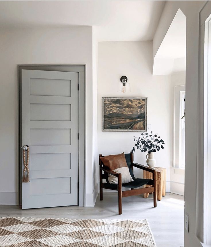 a living room with a checkered rug on the floor and an open door leading to another room