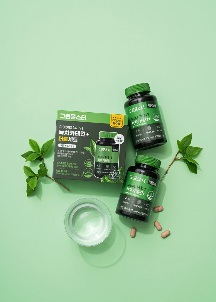 three bottles of vitamin supplements sitting on top of a green surface next to some leaves