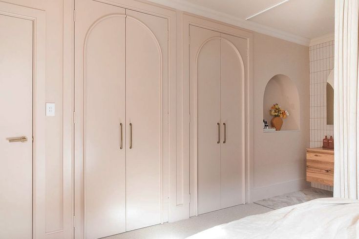 a bedroom with white closets and an arched doorway