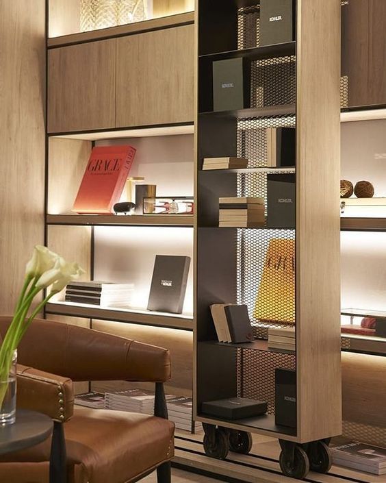 a room with many books on shelves and chairs next to each other in front of them