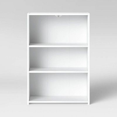 an empty white bookcase with three shelves