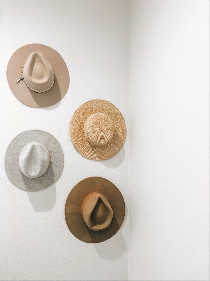 three hats hanging on the wall in a room