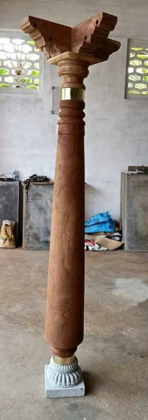 a large wooden pillar sitting on top of a cement floor in a room with windows