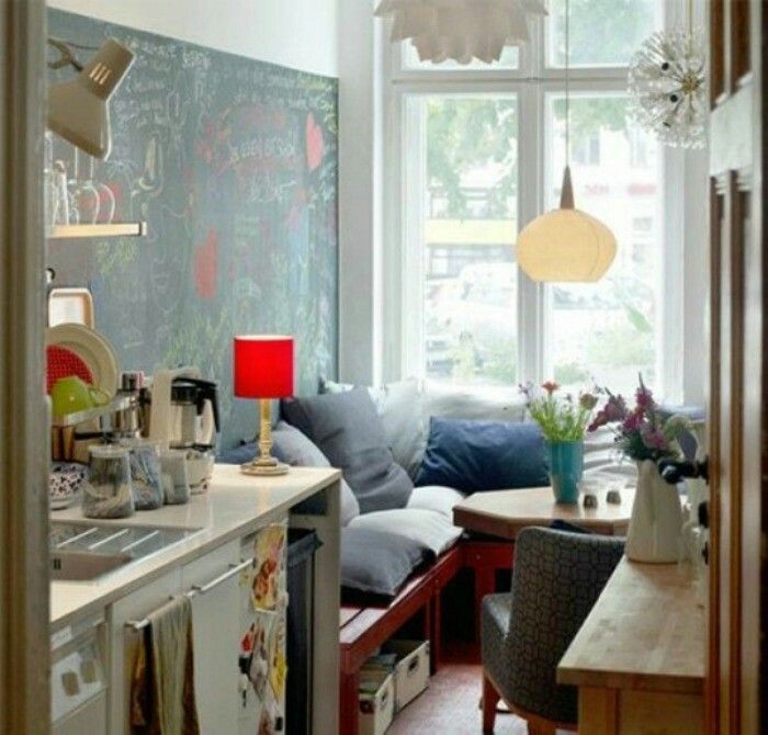 a living room filled with furniture next to a kitchen and dining room table in front of a window