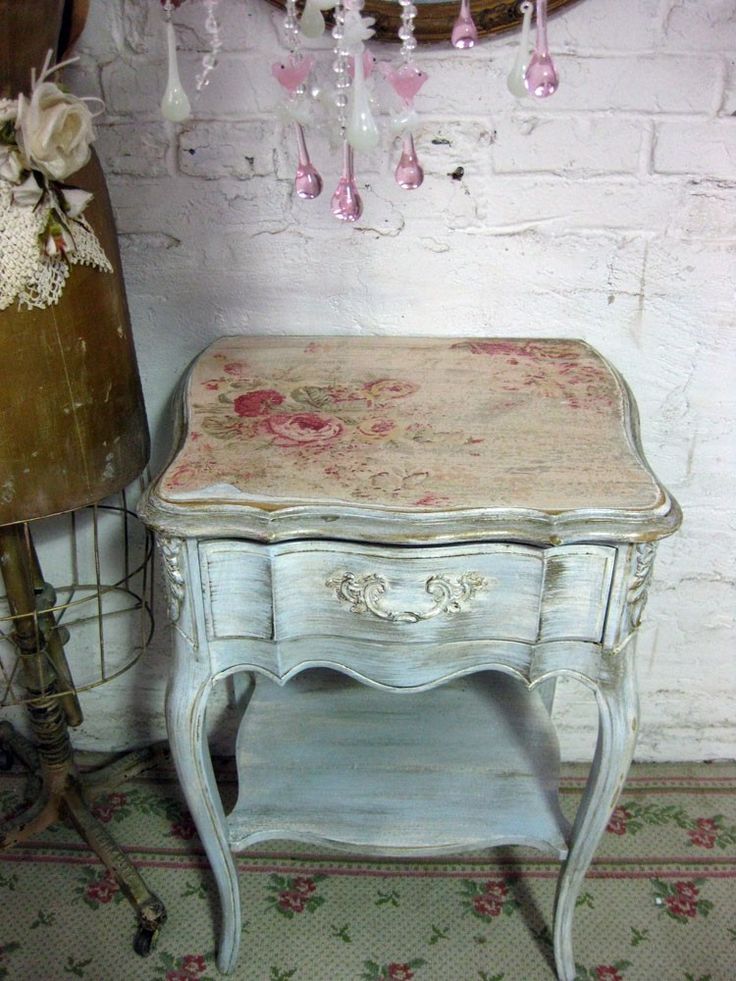 an old white table with pink flowers on it