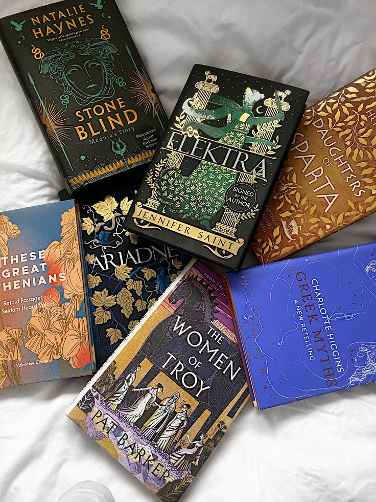 six books are laid out on a bed