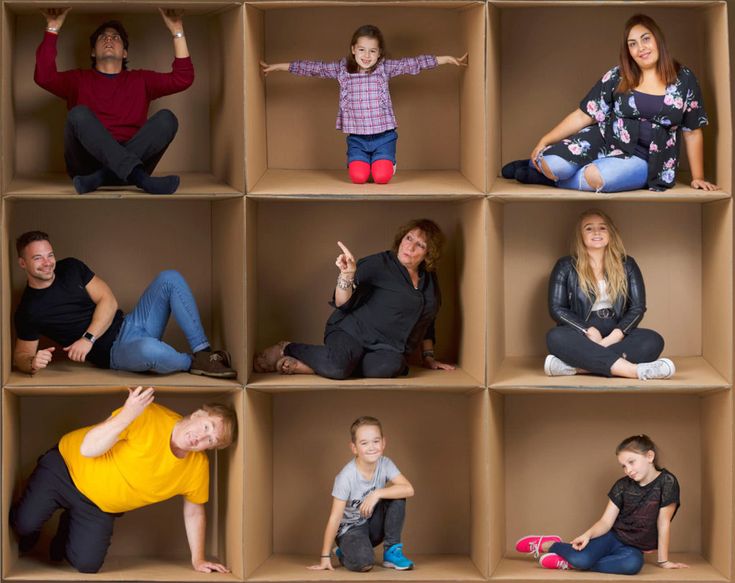 a group of people that are sitting in some cardboard boxes with their arms up and legs crossed