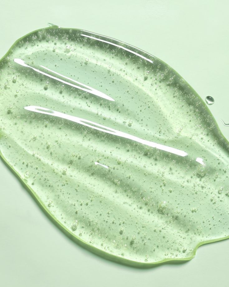 a green leaf shaped dish with water droplets on it