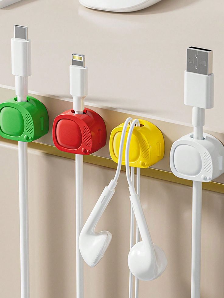 there are four different colored plugs attached to the side of a wall with ear buds