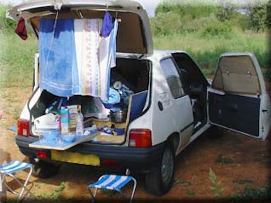 the back end of a van with its trunk open and clothes hanging out to dry