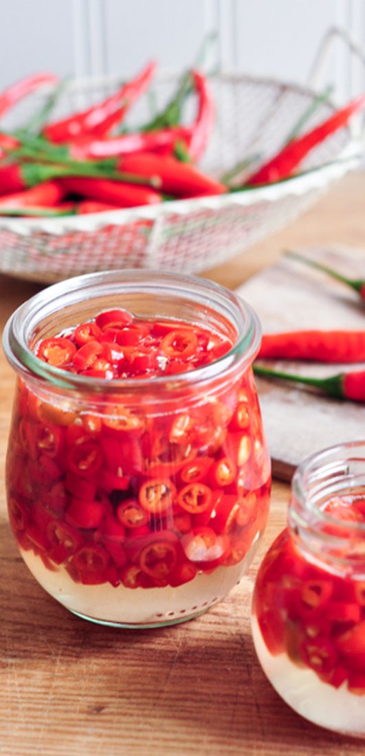 two jars filled with food sitting on top of a wooden table