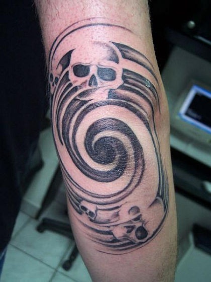 a man with a skull and swirl tattoo on his arm