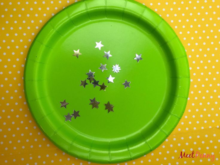 a green paper plate with silver stars on it