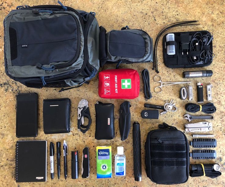 the contents of a travel bag are laid out on the floor next to each other