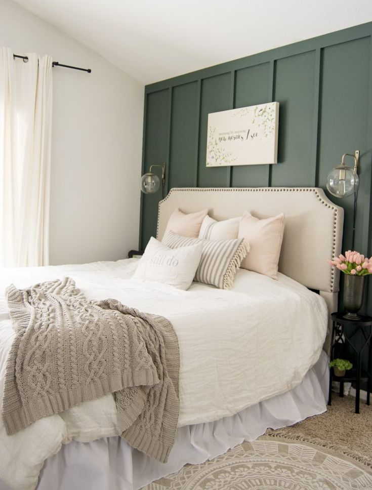 a white bed sitting in a bedroom next to a window