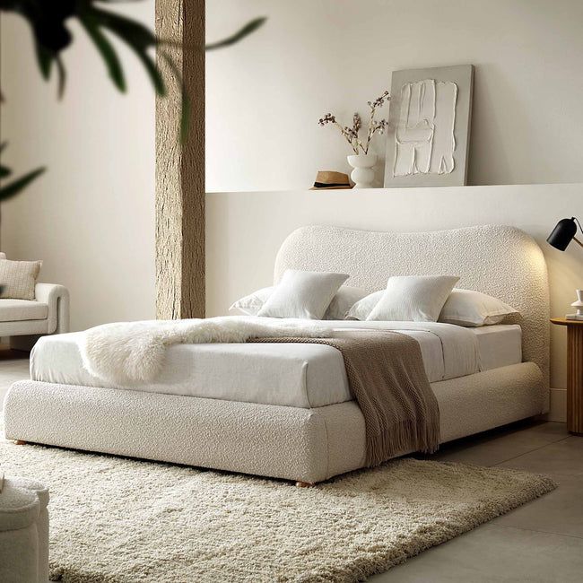 a white bed sitting in a bedroom on top of a rug