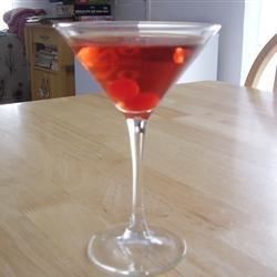 a glass filled with liquid sitting on top of a wooden table