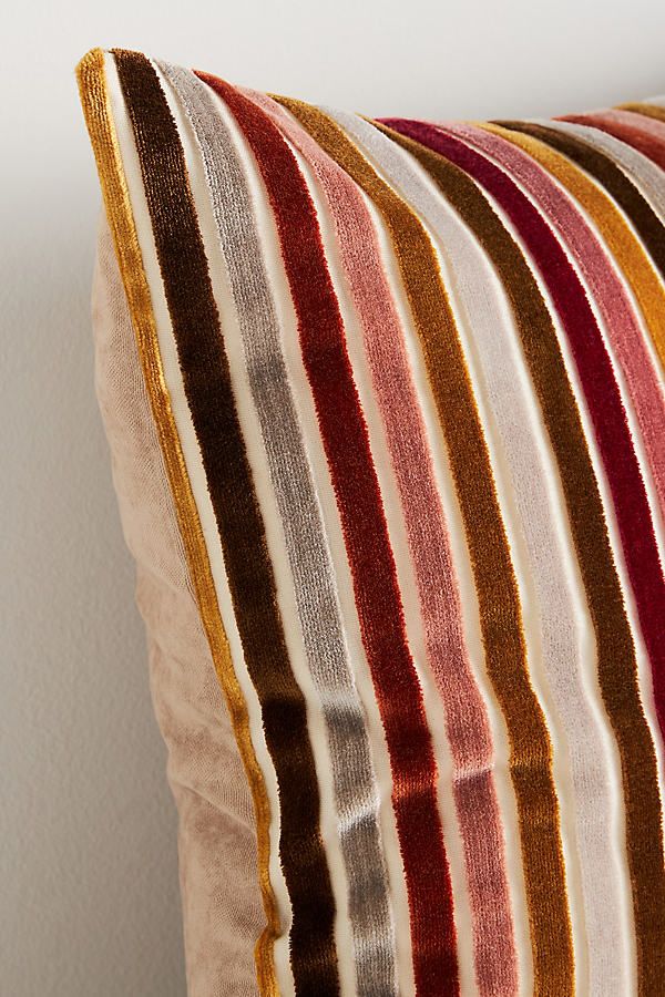 a striped pillow sitting on top of a wooden table