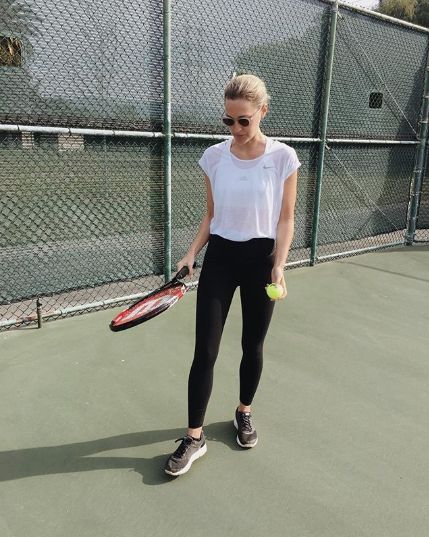 a woman holding a tennis racquet and ball