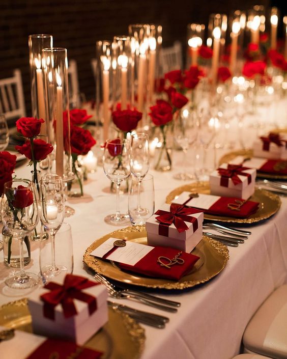 a table set with red roses and candles