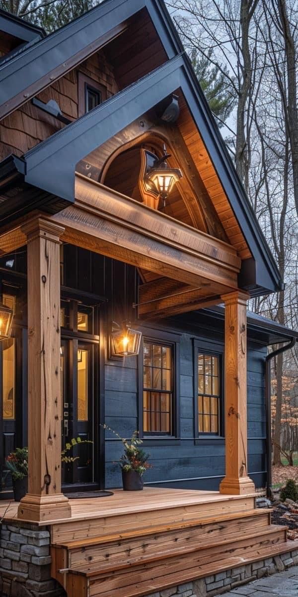 a small house with an attached porch and steps leading to the front door is lit up by two lights