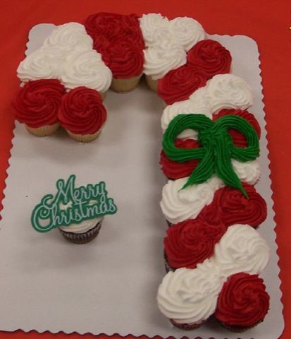 cupcakes decorated with red and white frosting are arranged in the shape of a letter