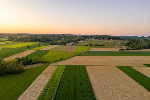 an aerial view of farm land at sunset