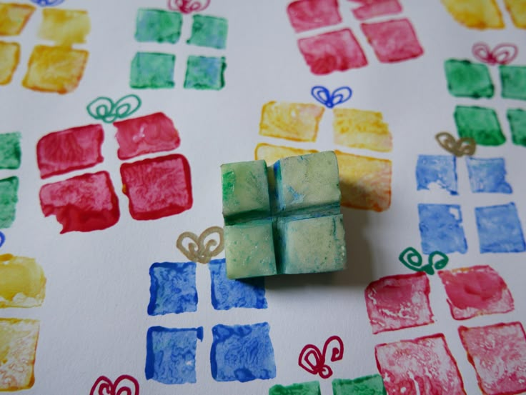 small cubes made out of colored paper sitting on top of a sheet of paper