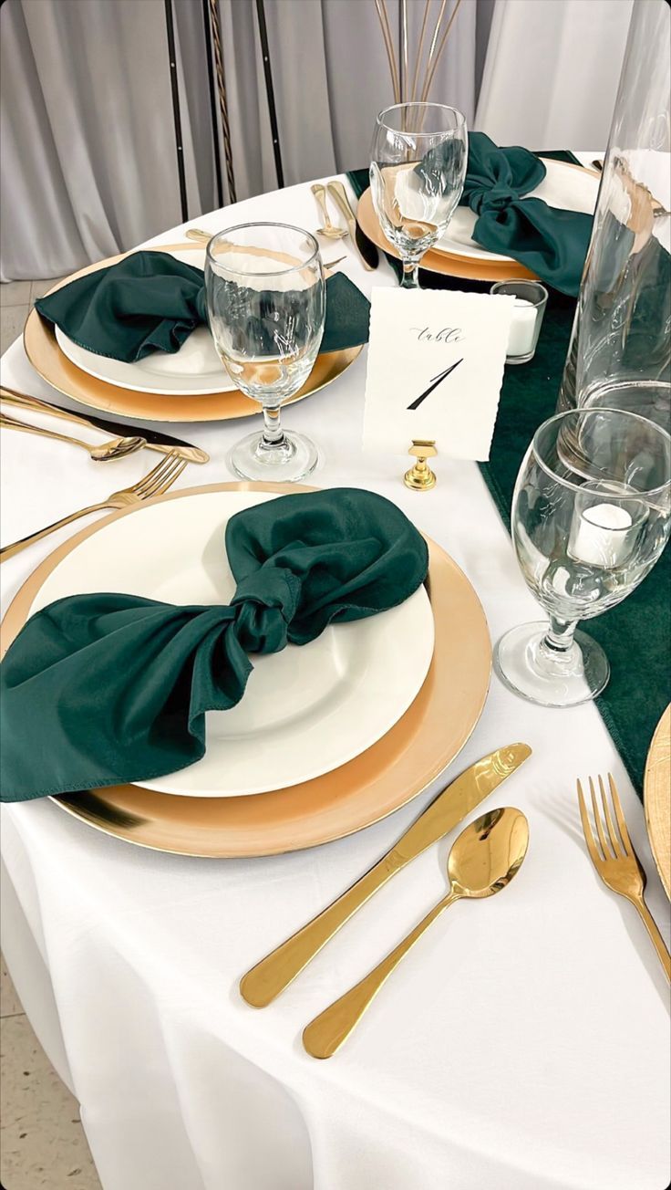 the table is set with gold and green place settings