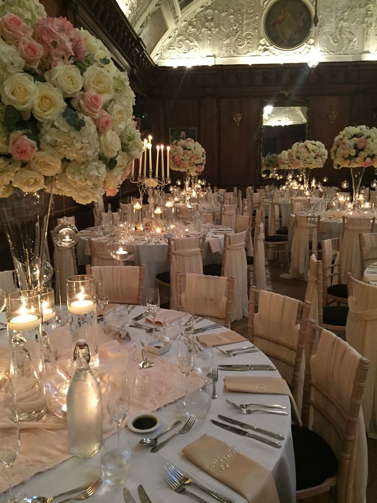 the tables are set with white and pink flowers