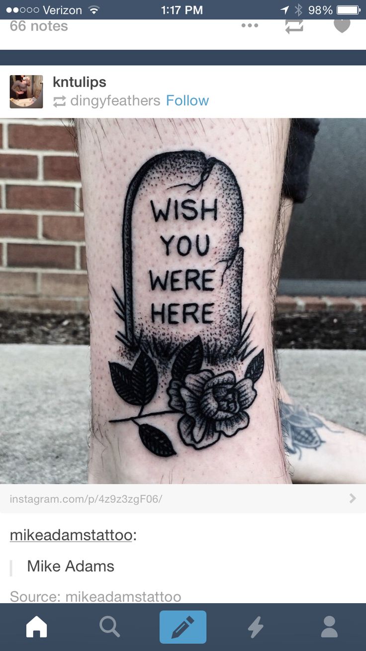 a black and white photo of a foot with a tattoo saying wish you were here