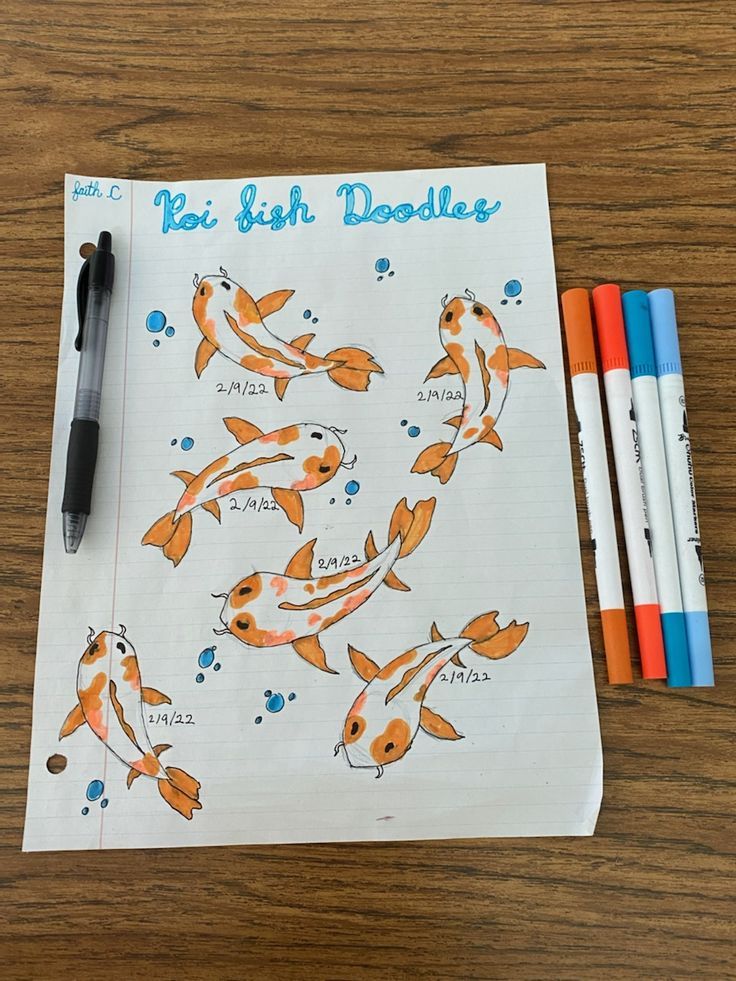 a notebook with fish doodles on it next to markers