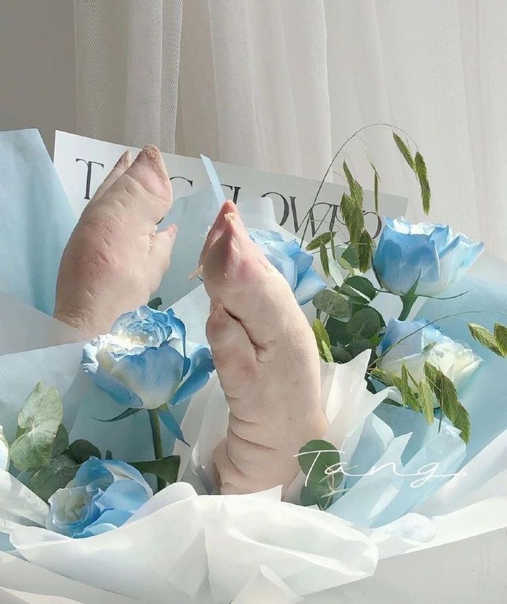 a person's bare feet are surrounded by blue flowers and white paper with the word love written on it