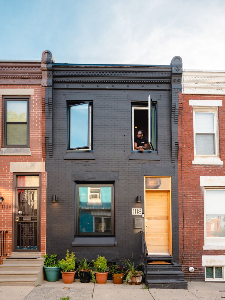 a man sitting in the window of an apartment building