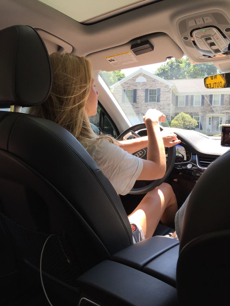 a woman sitting in the driver's seat of a car