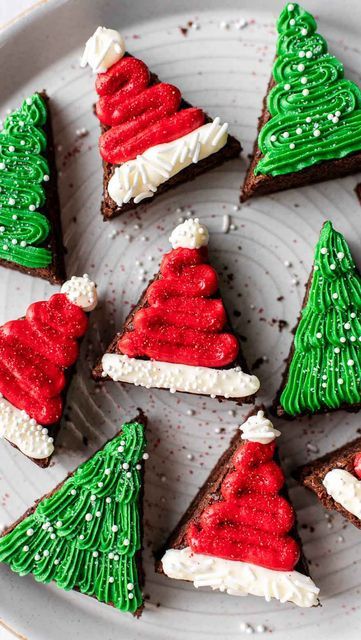 christmas cookies decorated with green and red icing on a white plate in the shape of trees