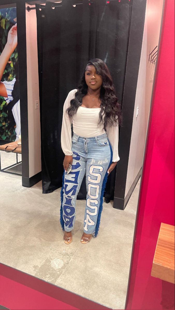 a woman standing in front of a mirror wearing high waisted jeans with the word's on them