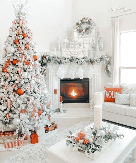 a living room decorated for christmas with white and orange decorations