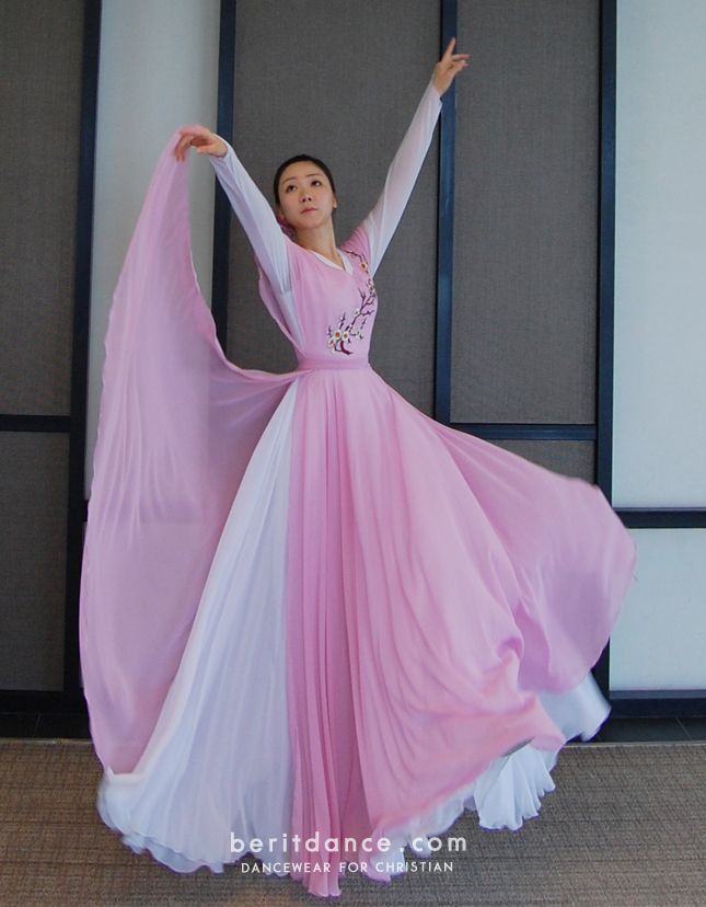 a woman in a pink and white dress is dancing