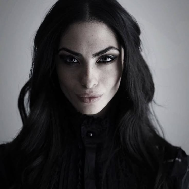 a woman with long black hair and dark makeup