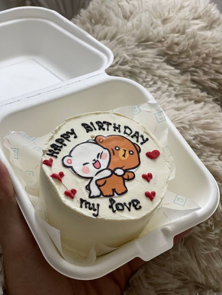 someone is holding up a cake in a plastic container that says happy birth day my love