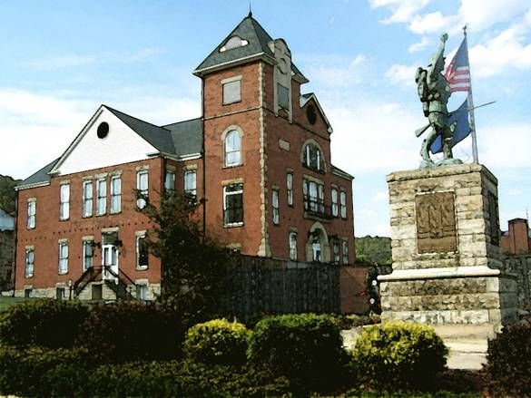 a large brick building with a statue in front of it and a flag on top